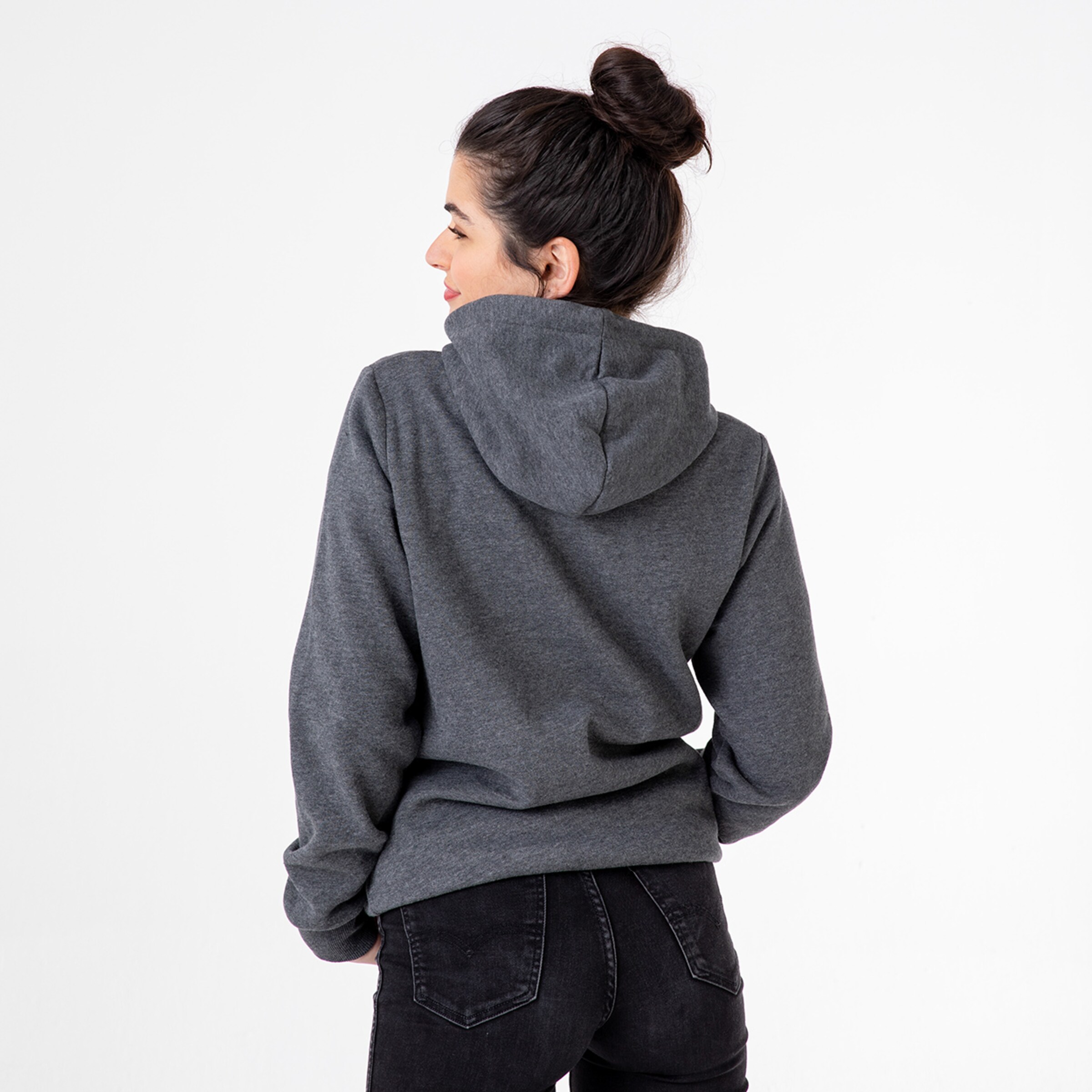Frau mit Dutt trägt einen grauen Kapuzenpullover von hinten.
