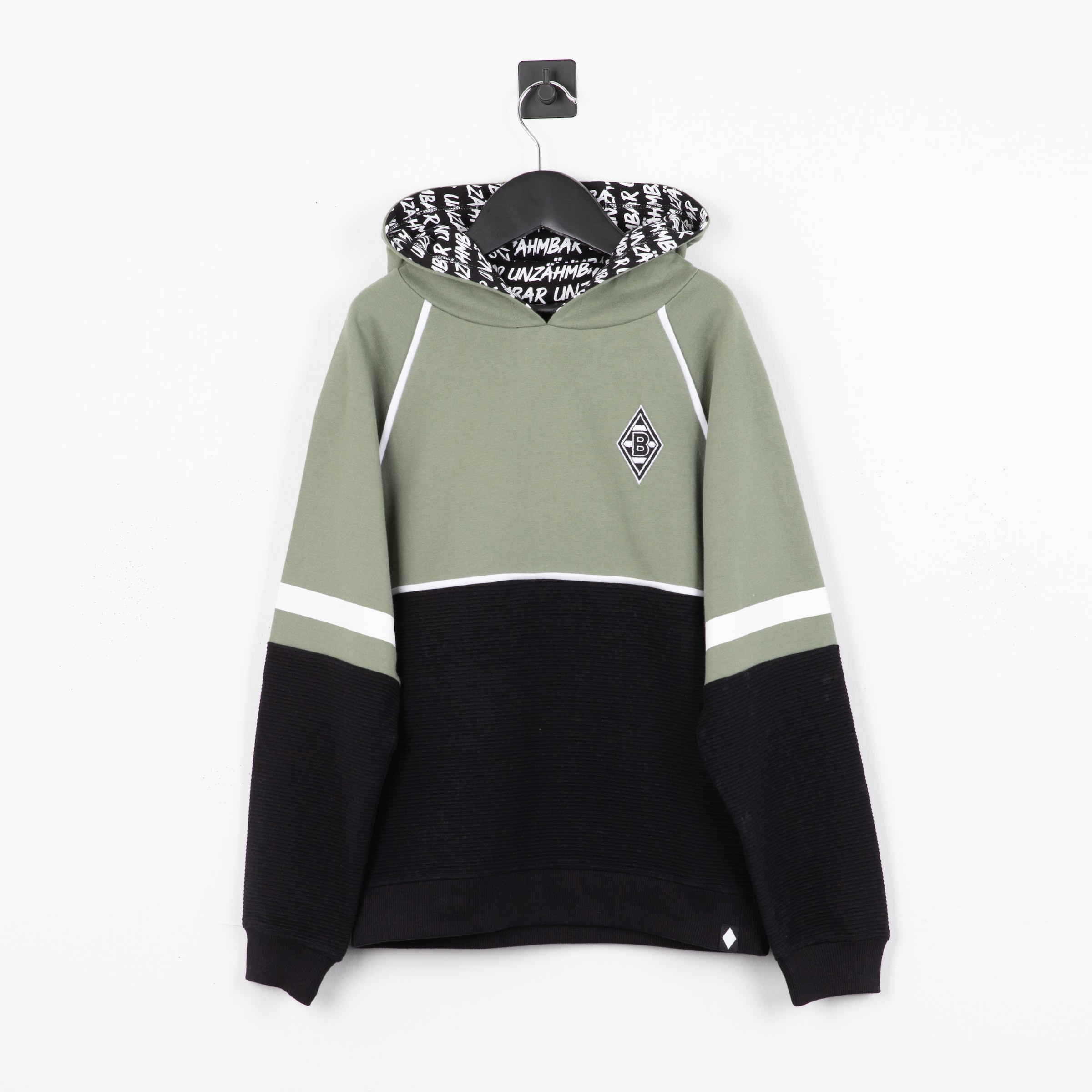 Grüner und schwarzer Borussia Mönchengladbach Hoodie mit weißen Streifen, Rauten-Logo und gemustertem Kapuzenfutter vor weißer Wand.