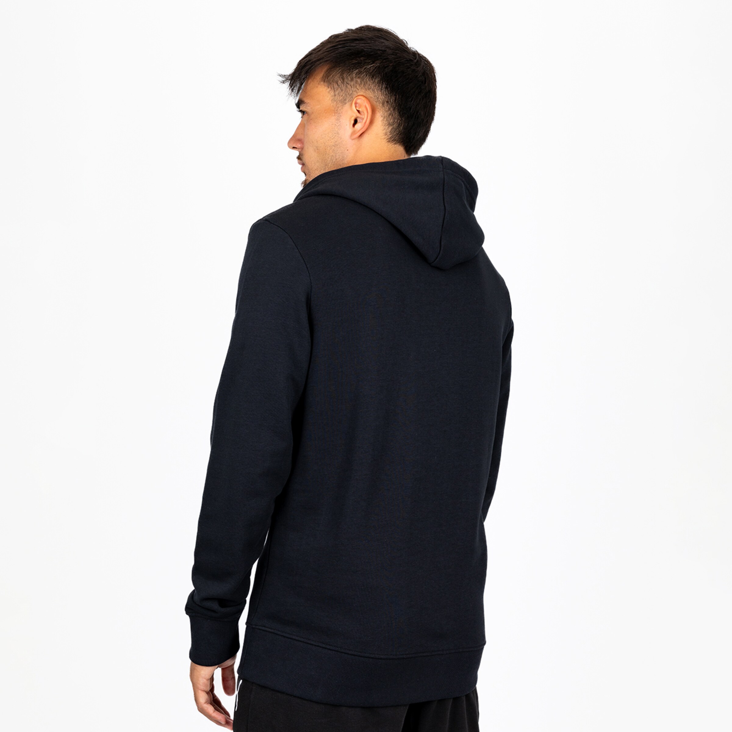 Rückansicht eines Mannes in einem dunkelblauen Kapuzenpullover vor weißem Hintergrund.