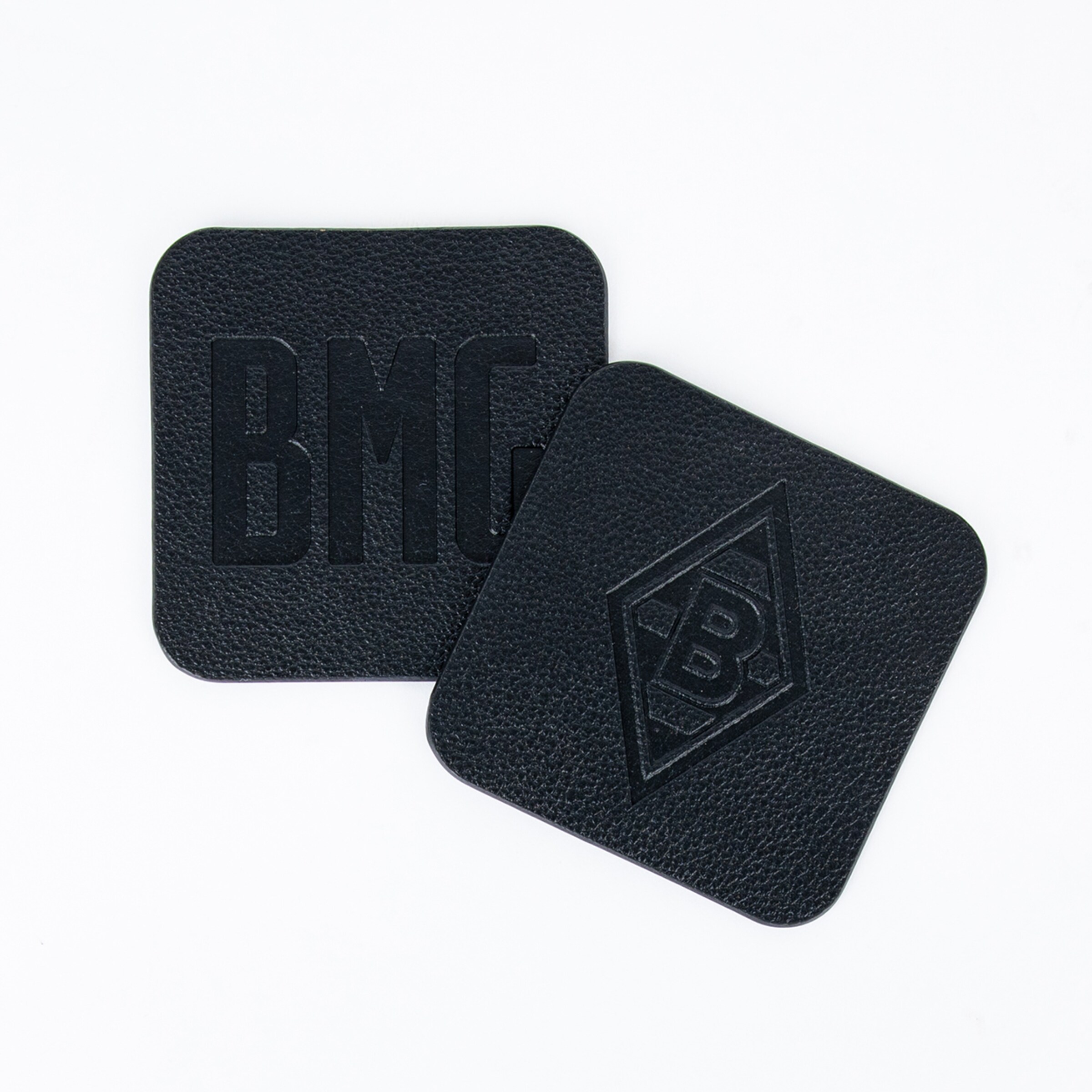 Black coasters embossed with BMG and the logo.