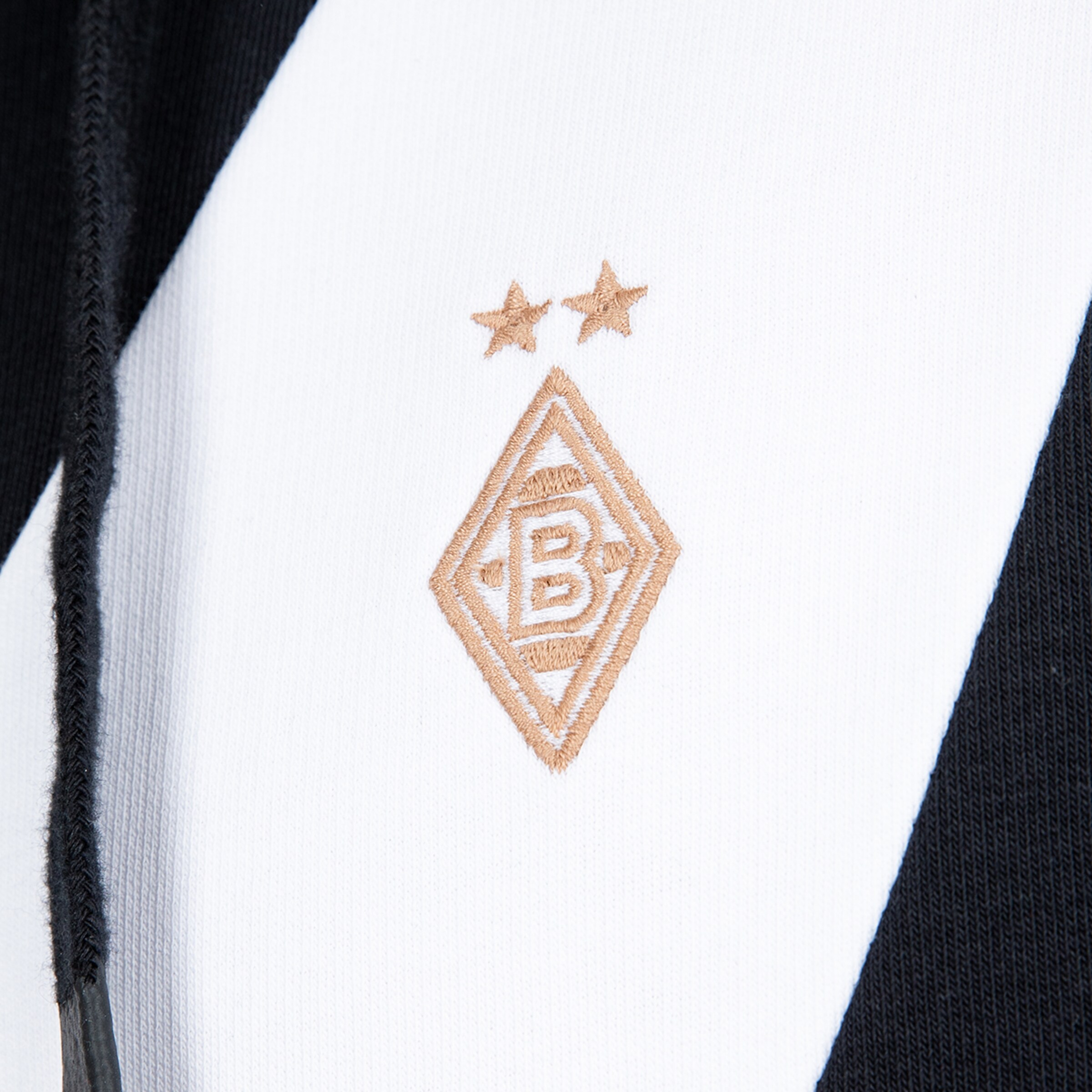 Besticktes goldfarbenes Logo von Borussia Mönchengladbach mit zwei Sternen auf schwarz-weißem Stoff.
