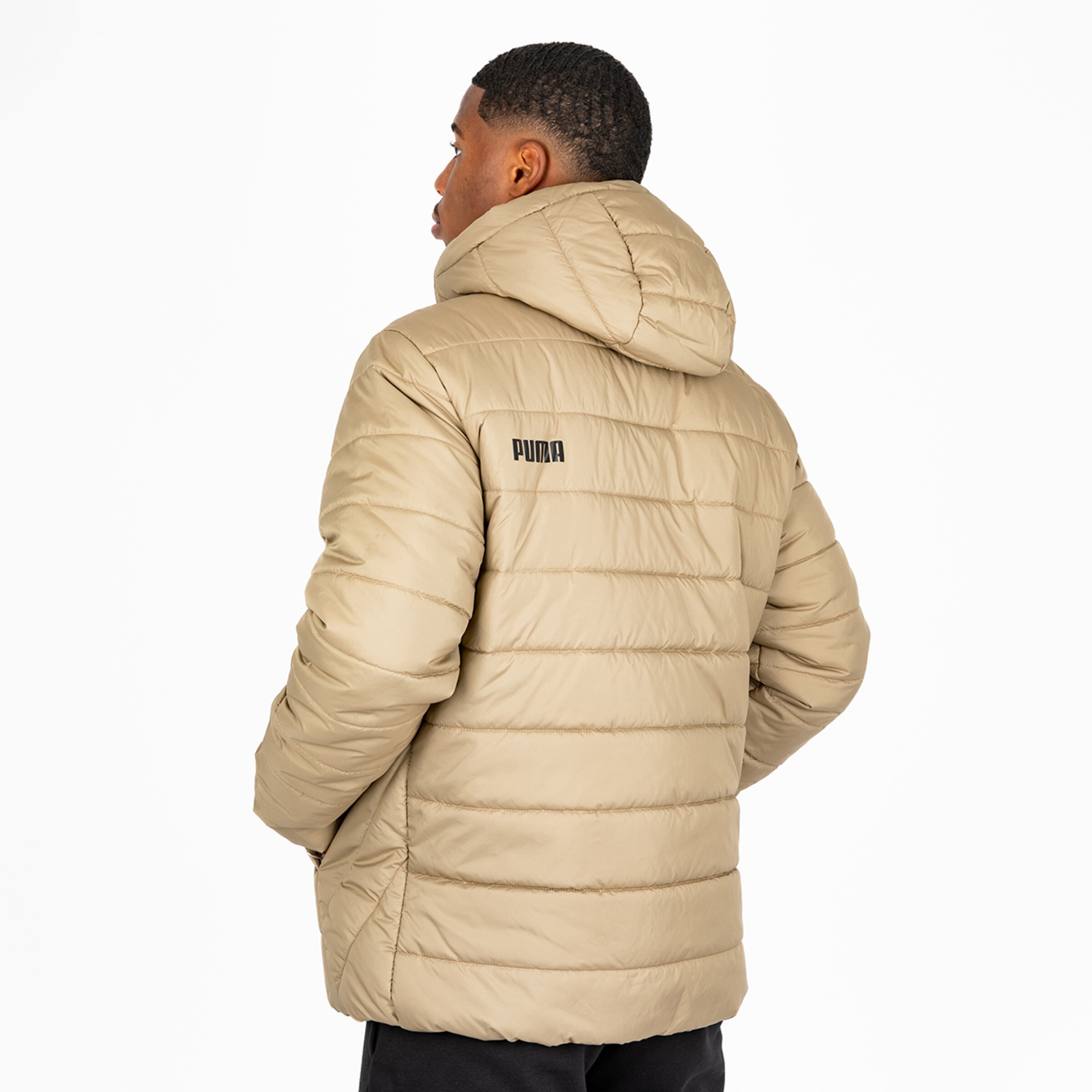 Mann trägt eine beige PUMA Daunenjacke mit Kapuze und zeigt den Rücken.