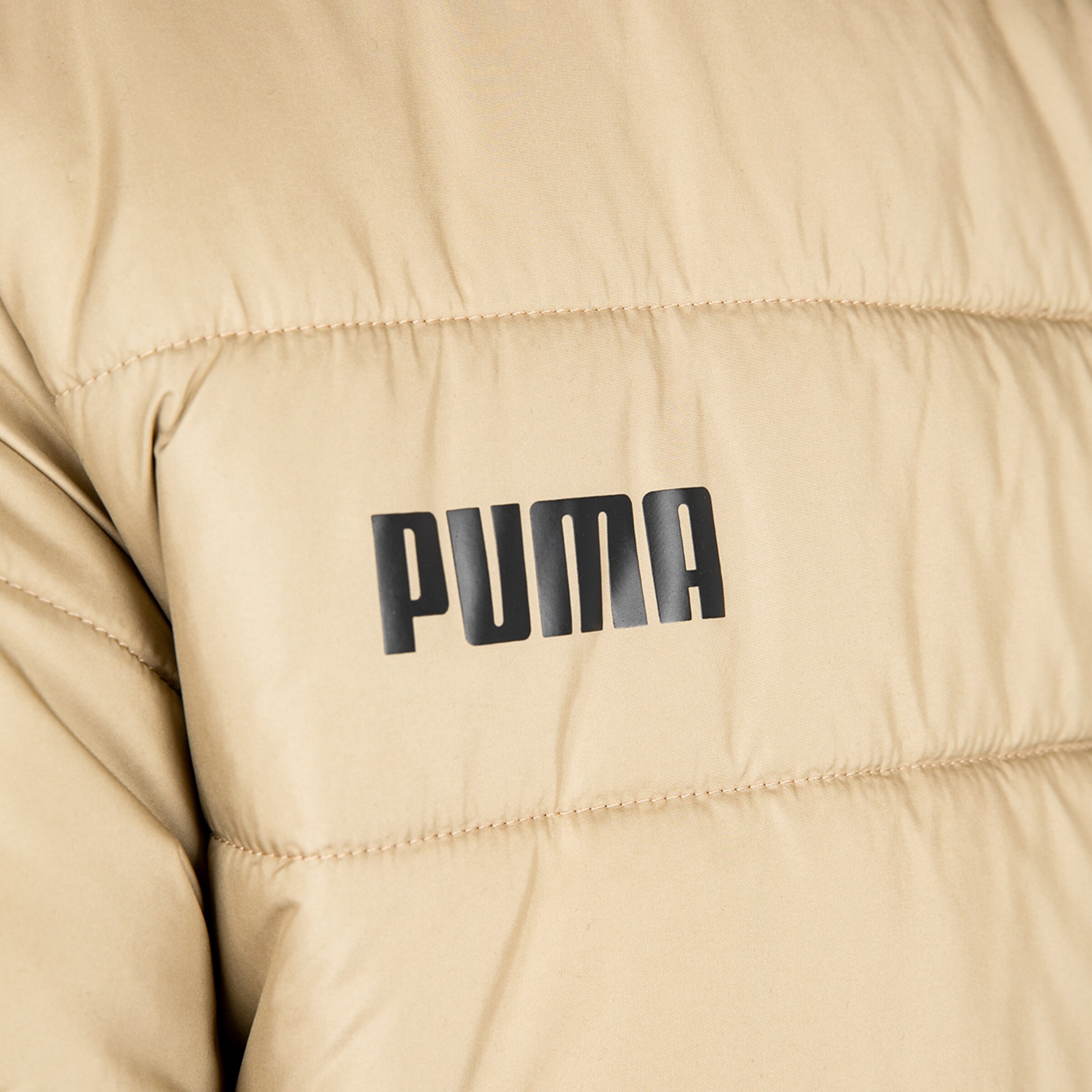 Beige Steppjacke mit PUMA-Logo auf der Brust.