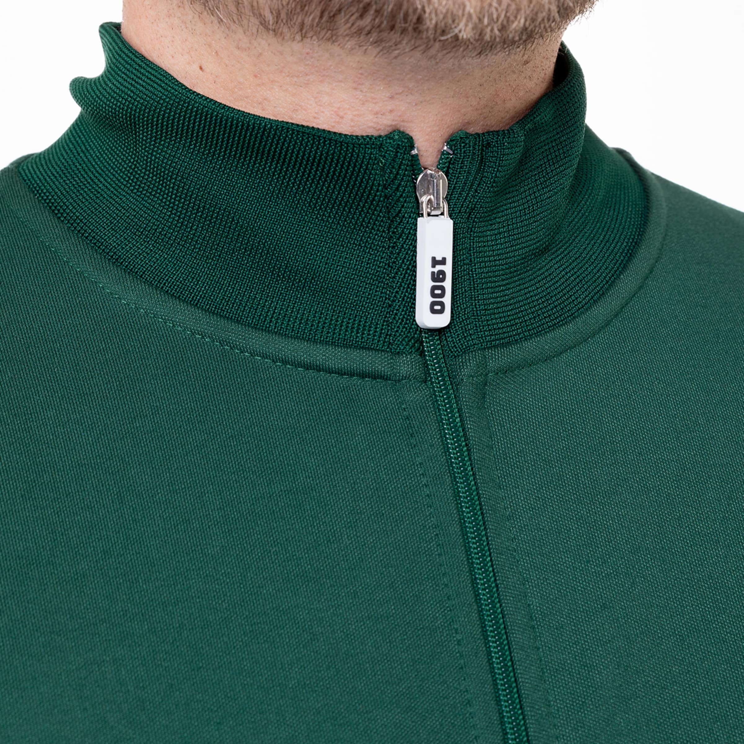Nahaufnahme eines grünen Sportoberteils mit Reißverschluss und Stehkragen.
