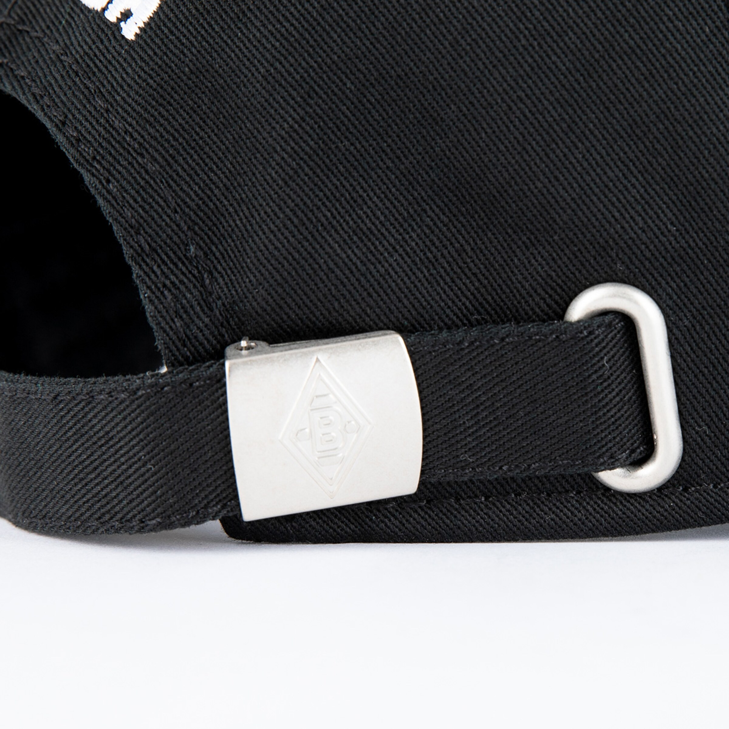 Metallverschluss eines schwarzen Baseballcaps mit dem Schriftzug Borussia Mönchengladbach.