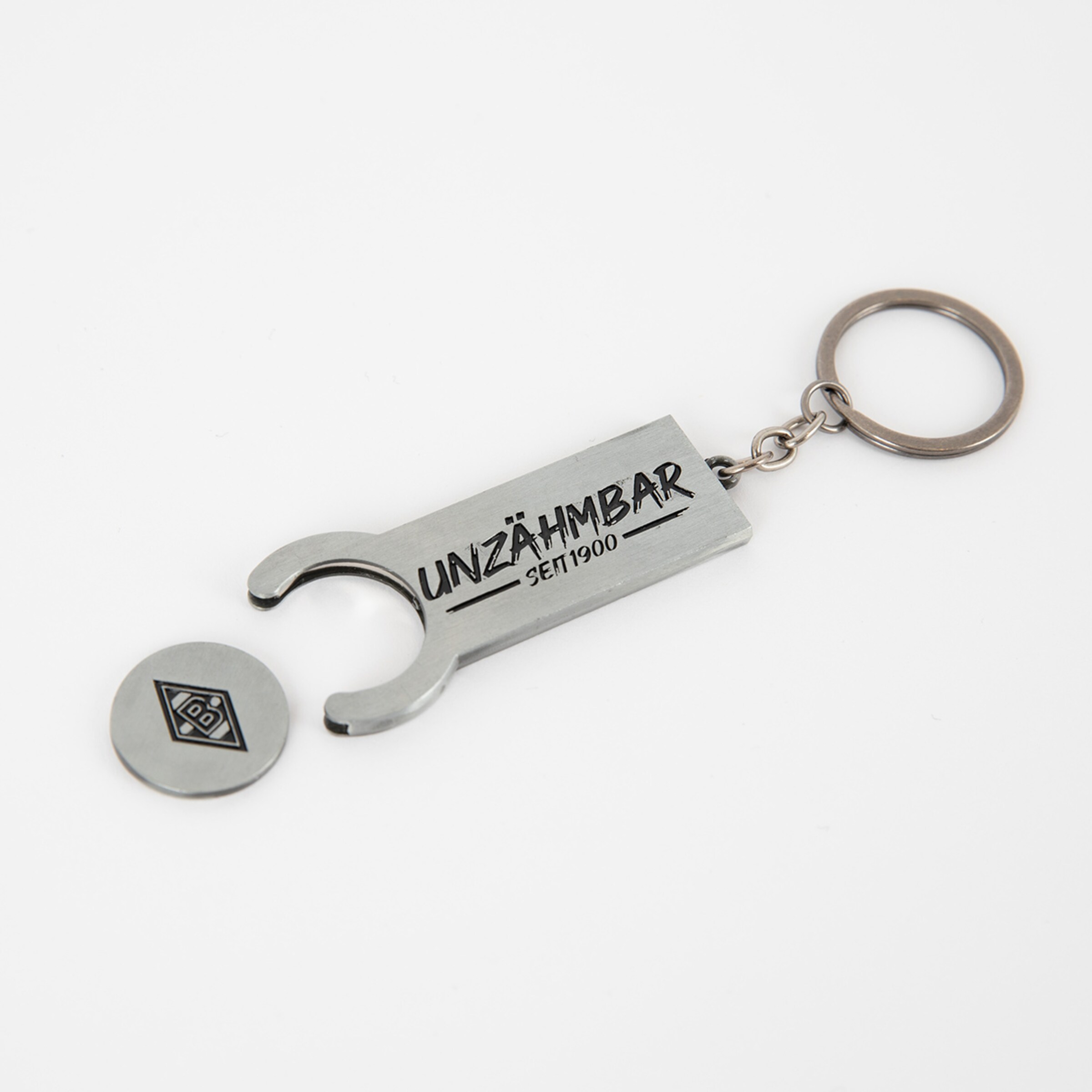 Schlüsselanhänger in silbernem Design mit Aufschrift UNZÄHMBAR SEIT 1900 und einem runden Anhänger.