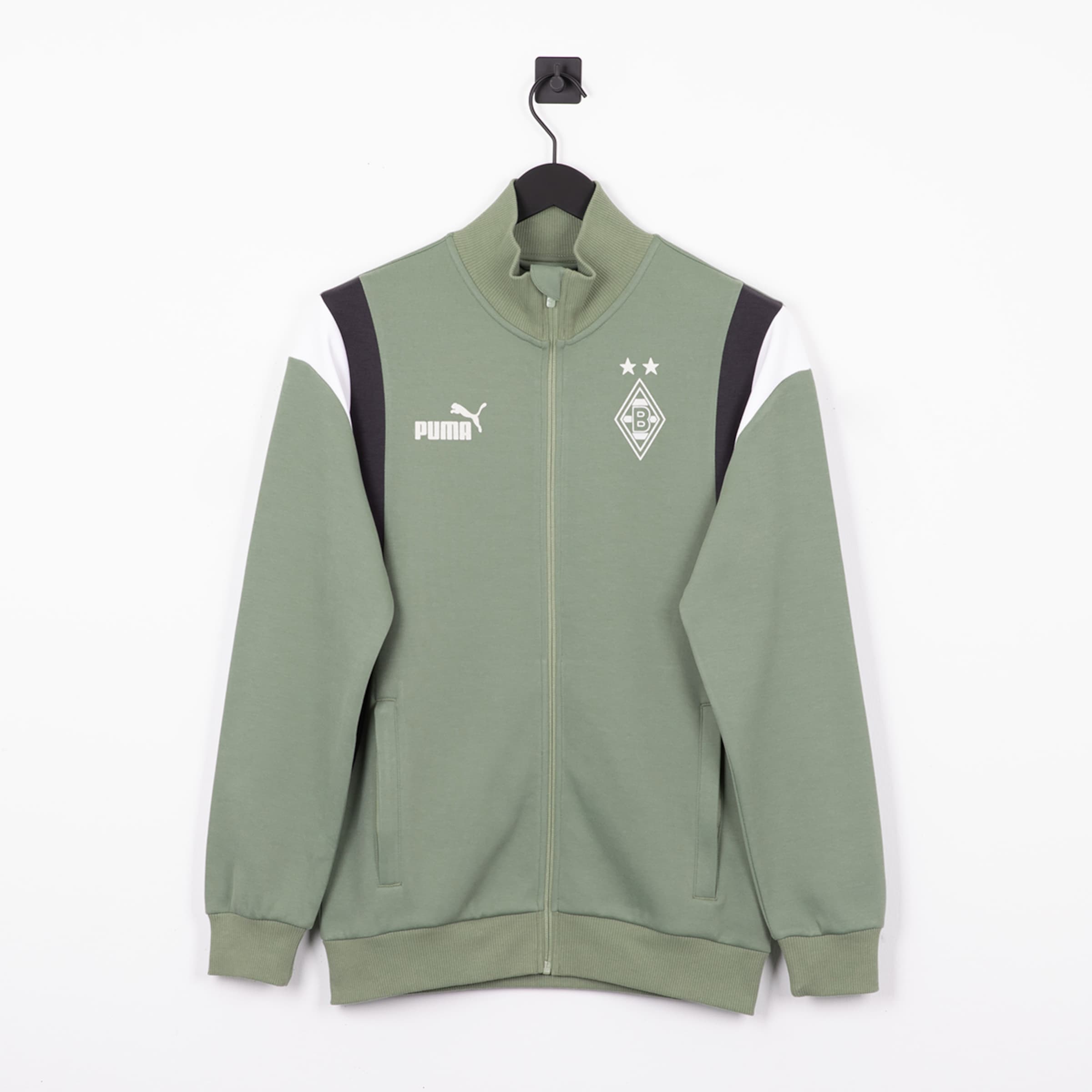 Grüne Puma Trainingsjacke von Borussia Mönchengladbach mit Reißverschluss, weißem Logo, Wappen und Schulterstreifen vor weißem Hintergrund.