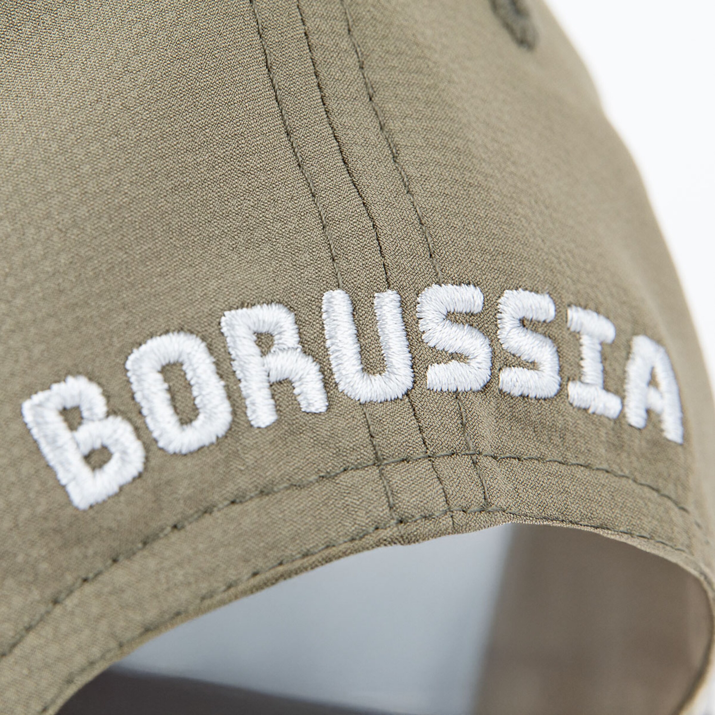 Close-up of a caps stitching displaying the word BORUSSIA in white letters.