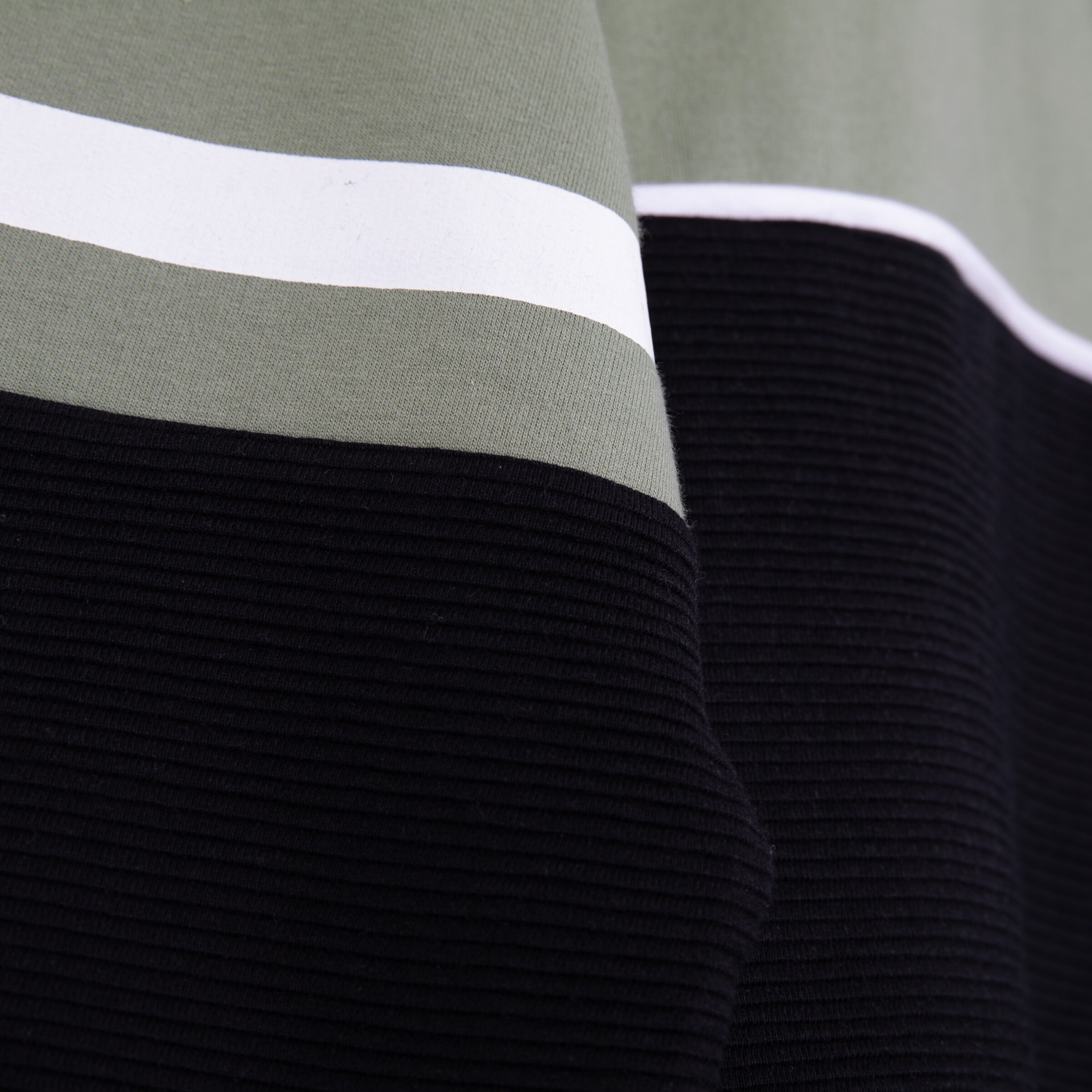 Nahaufnahme eines Stoffes mit grauer und schwarzer Struktur sowie weißen Streifen.