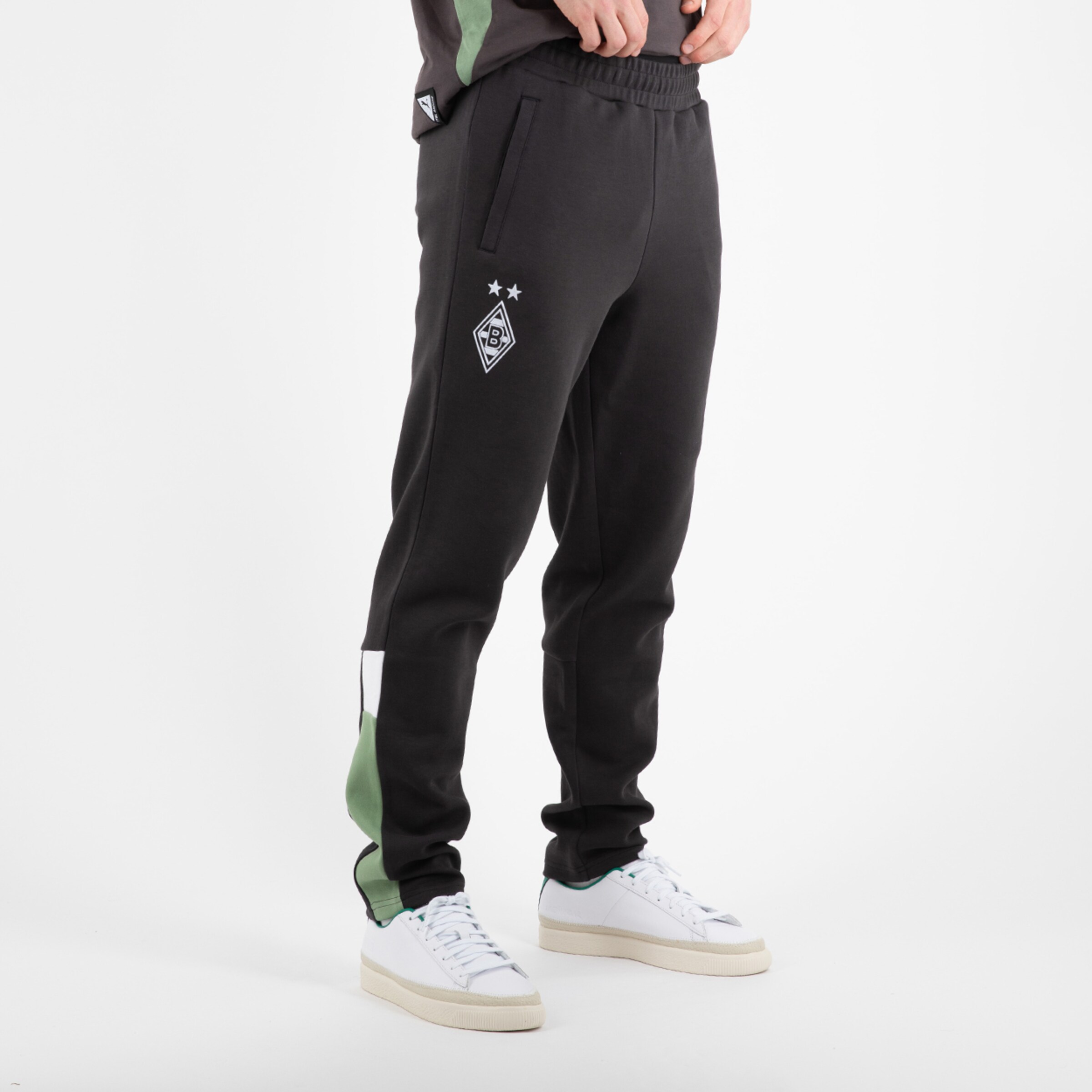 Schwarz-grüne Jogginghose mit Borussia Mönchengladbach-Logo auf der linken Seite.