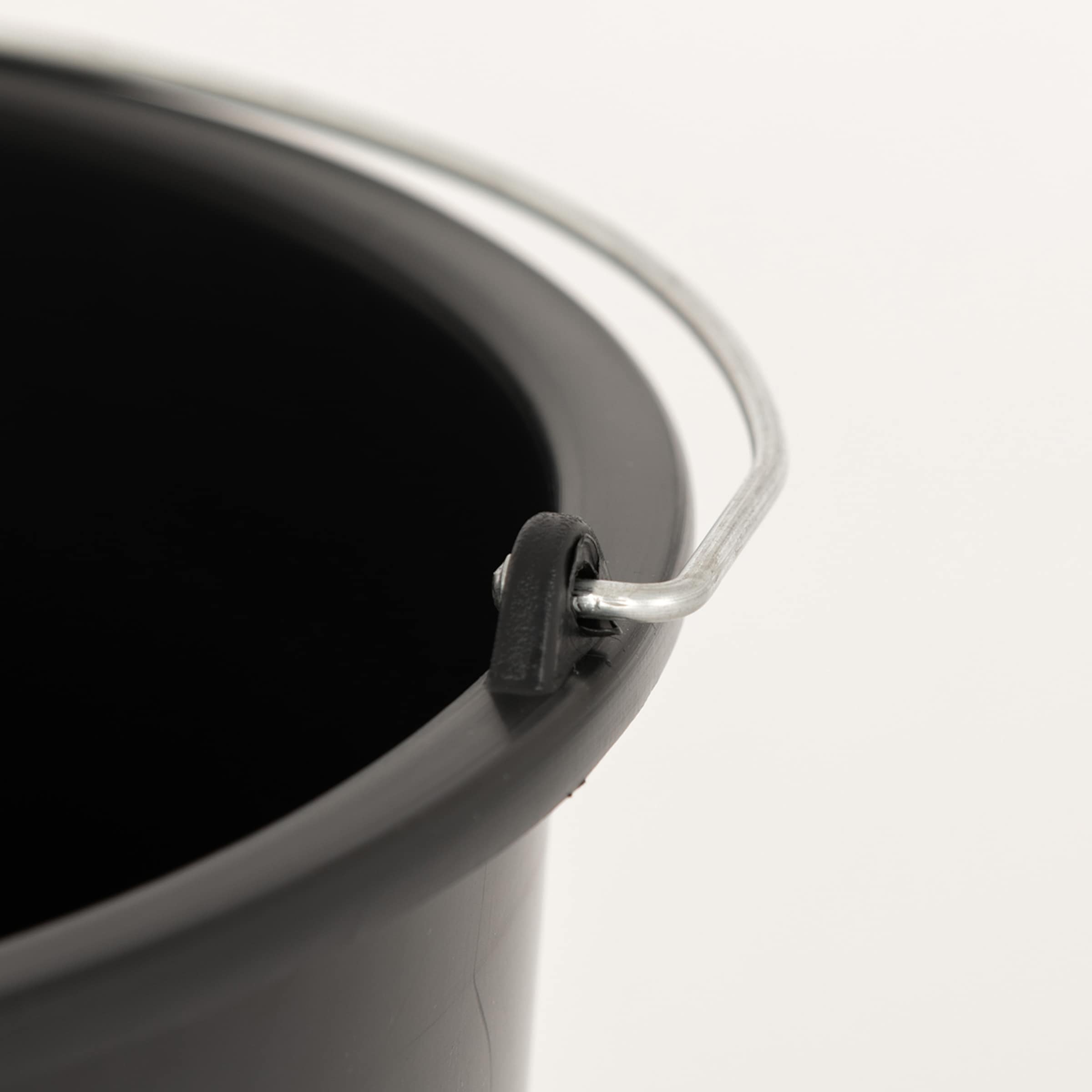 Close-up of the rim of a black plastic bucket with a silver metal handle attached to a black plastic bracket.