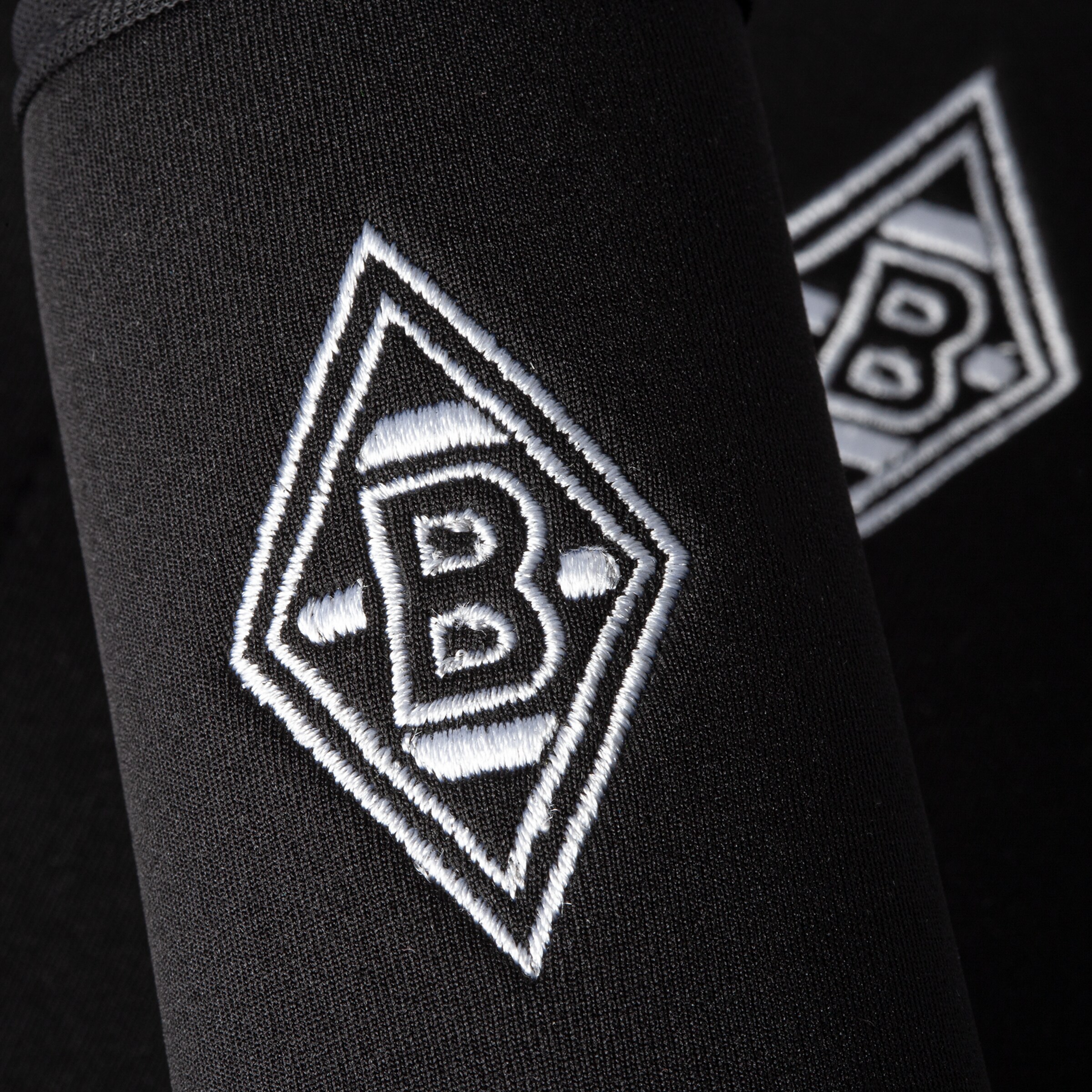Schwarz-weiß gesticktes Borussia Mönchengladbach-Logo auf Textilmaterial.