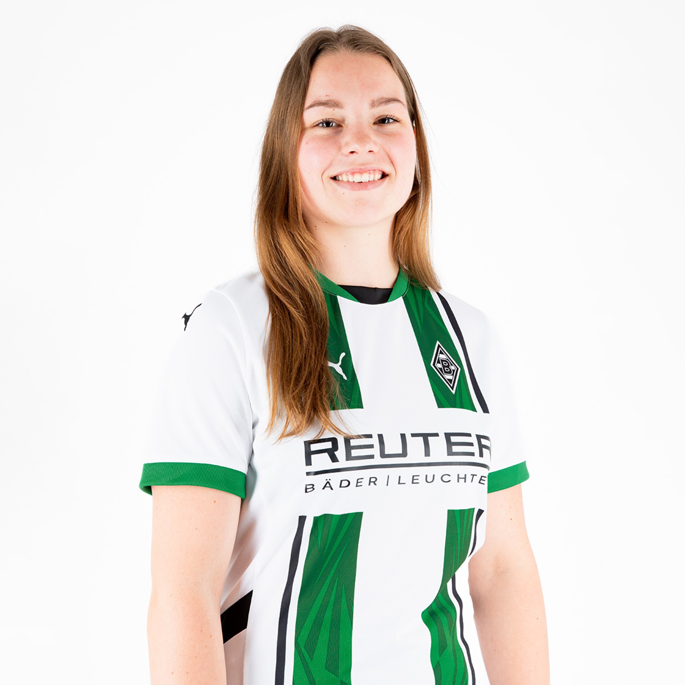 Eine junge Frau in einem weißen Fußballtrikot mit grünen Details und dem Logo von Borussia Mönchengladbach.