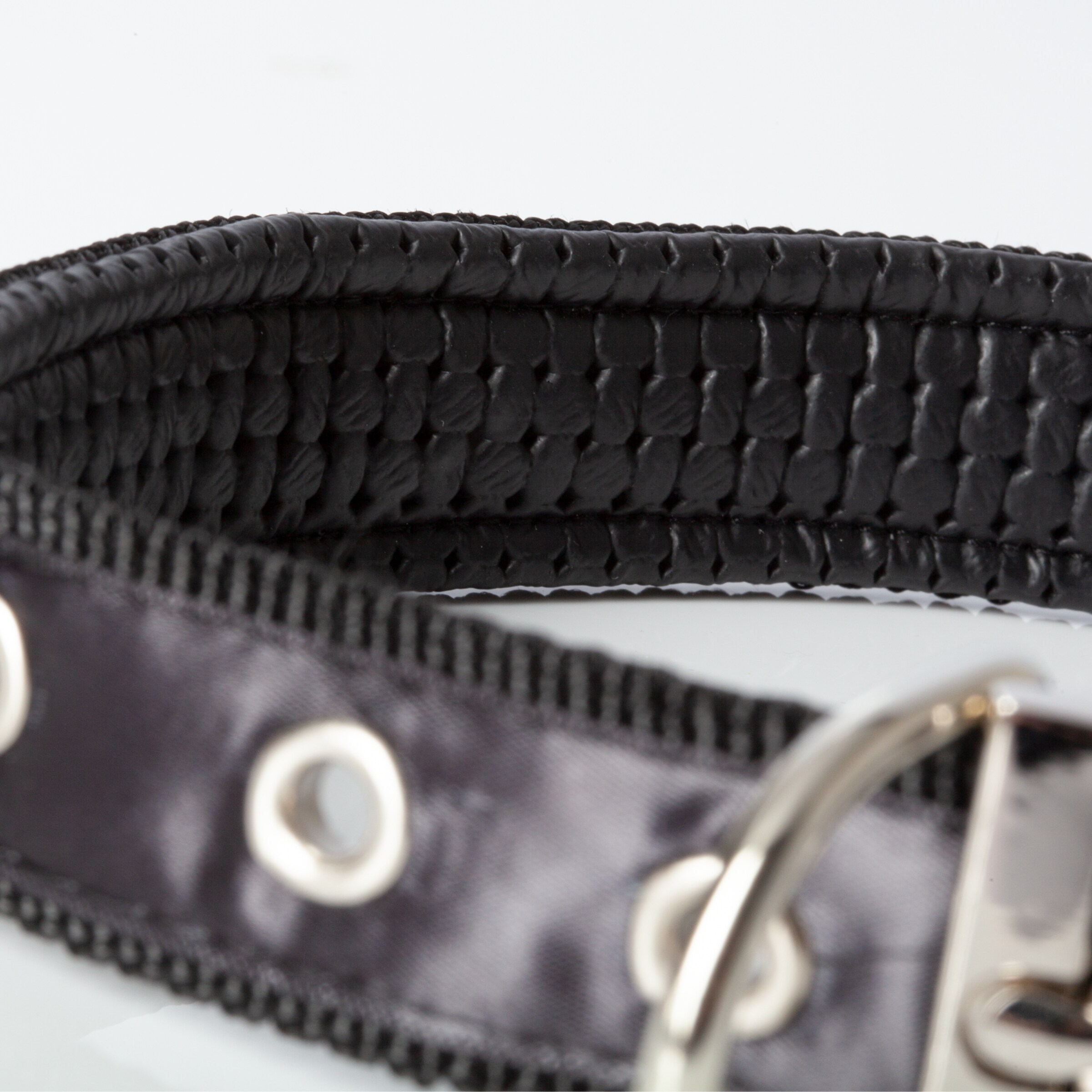 Black woven belt with metal buckle and eyelets.