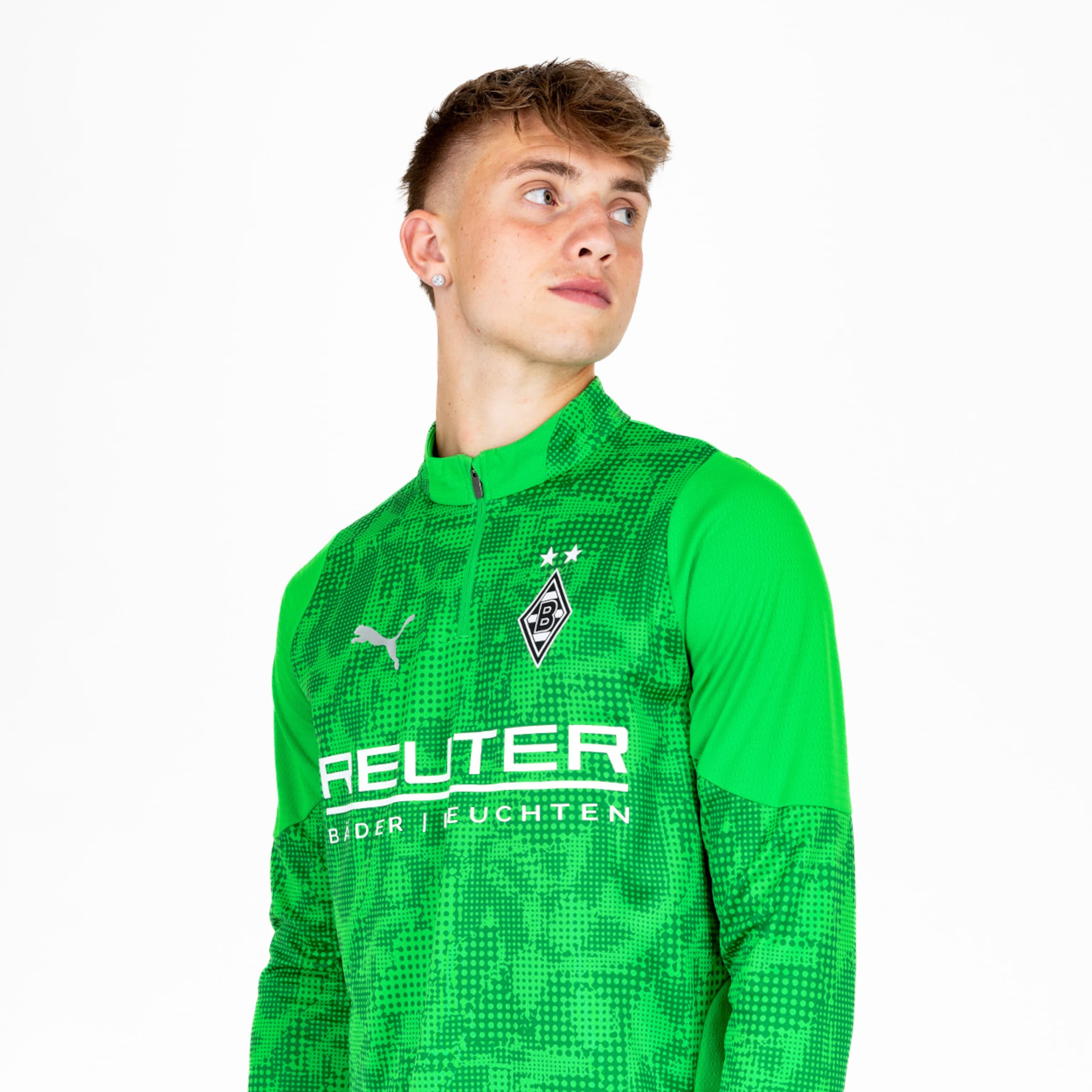 Torwart in grünem Trainingsanzug mit Vereinslogo und Sponsorenaufschrift.