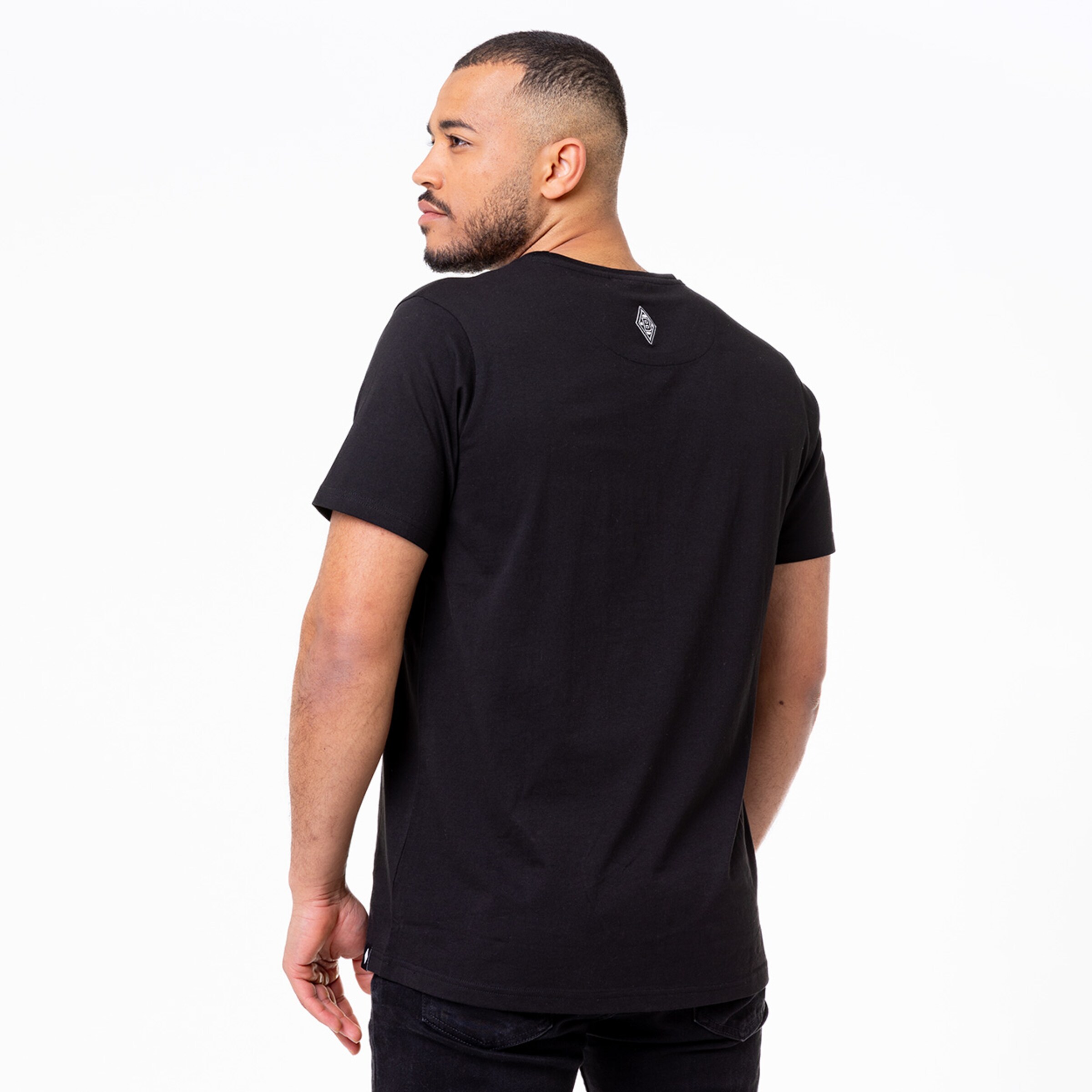 Mann trägt schwarzes T-Shirt von Borussia Mönchengladbach steht von hinten.